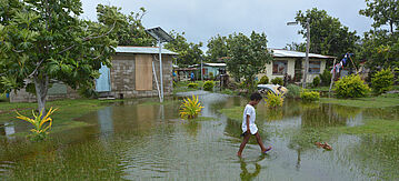 Fidschianisches Mädchen geht über überschwemmtes Land in Fidschi