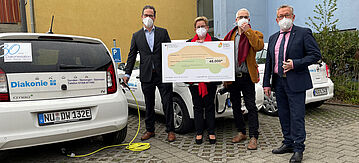 Florian Pronold (links) überreicht einen Förderscheck aus dem Flottenaustauschprogramm Sozial & Mobil an die Diakonie Ulm