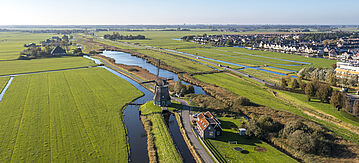 Holländische Polderlandschaft mit Windmühle und holländischem Dorf