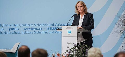 Veranstaltungssaal mit Blick auf die Bühne und Steffi Lemke am Rednerpult