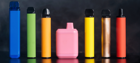 Elektronische Zigaretten in verschiedenen Formen auf schwarzem Hintergrund mit Rauch