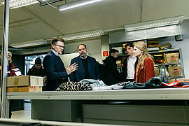 Carsten Schneider spricht mit den Helfenden der Deutschen Kleiderstiftung.