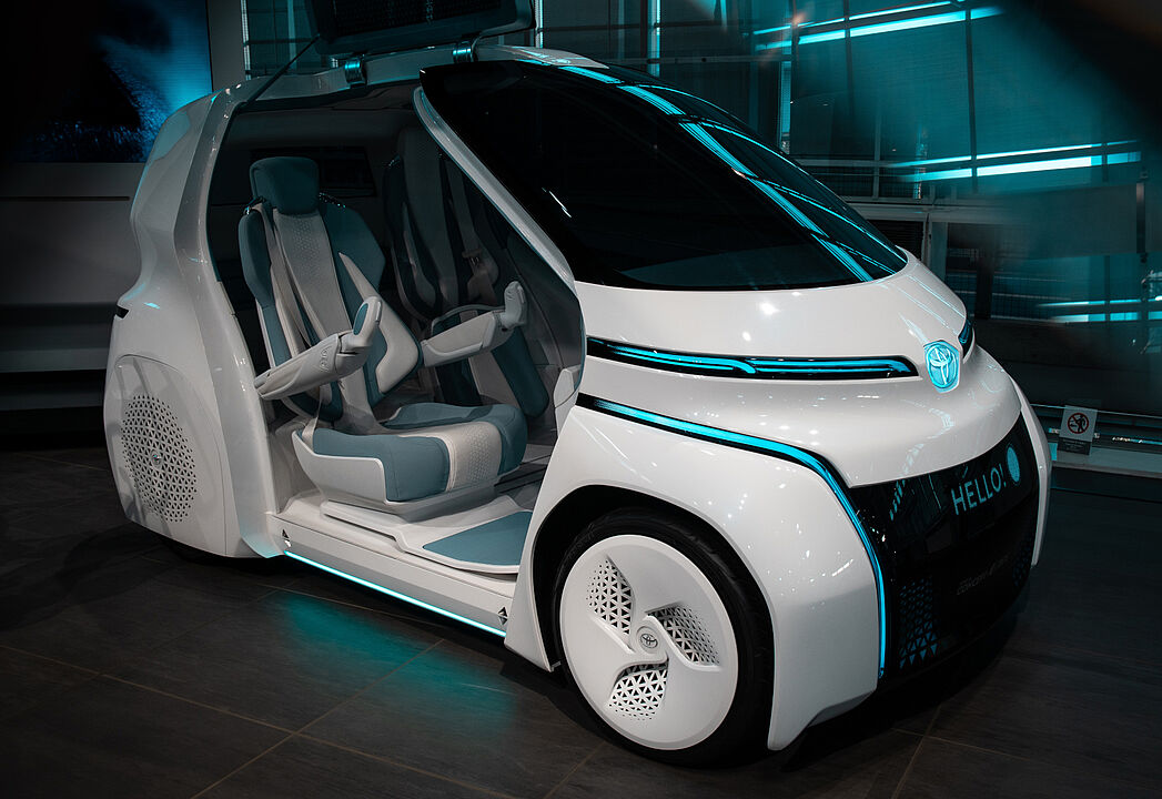 Ein futuristisches Auto, bei dem die Türen offen sind und man in den Innenraum schauen kann.