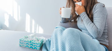 Kranke Frau putzt sich die Nase