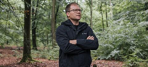 Carsten Schneider steht im Wald.