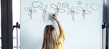 Mädchen zeichnet Windräder