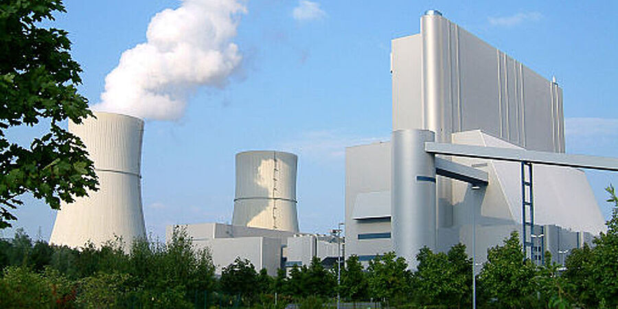 Blick auf mehrere Gebäude und Kühlturm eines Kraftwerks