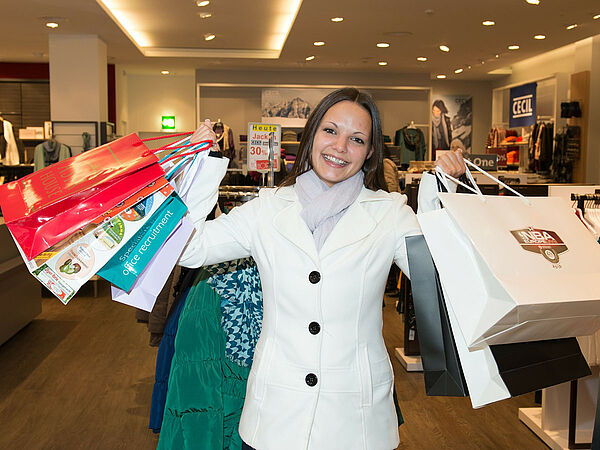 Person im Geschäft mit vielen Einkaufstüten