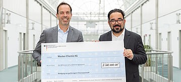 Zwei Personen mit großem Fördercheck