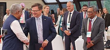 Der indische Umweltminister Bhupender Yadav und Bundesumweltminister Carsten Schneider begrüßen sich.. Weitere Informationen siehe Bildunterschrift