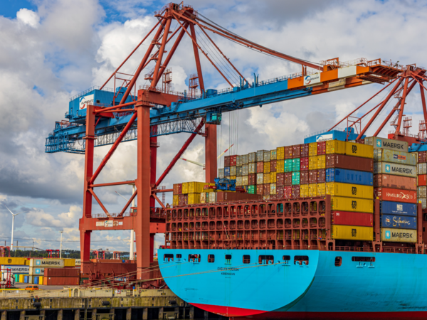 Kran hebt Container auf großes Containerschiff.