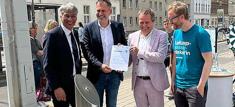 Gruppenbild: Staatssekretär Stefan Tidow und OB Tobias Schick nehmen einen von drei neuen Trinkbrunnen in Brandenburg in Betrieb.
