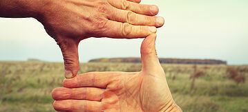 Hände zeigen auf ein Feld