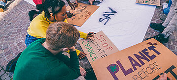 Jugendliche malen Plakate für Klima-Demo