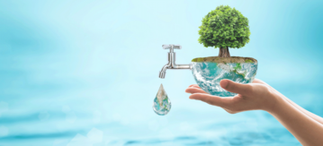 Hände halten eine Erdkugel aus der Wasser läuft