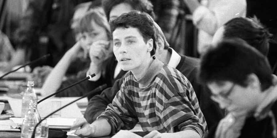 Schwarz-Weiß-Foto zeigt mehrere Personen an einem Verhandlungstisch.