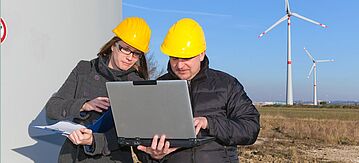 Technikerin und Techniker an einer Windkraftanlage