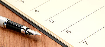 Kalender und Füller auf einem Tisch