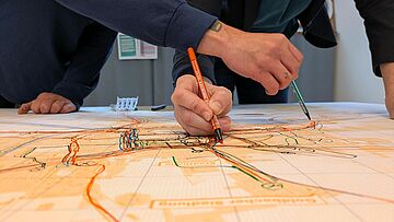 Hände markieren Stift auf Plan