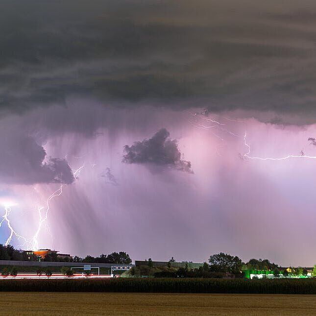 Unwetterwolke mit Blitzen über einer Landschaft in Bayern