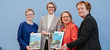 Vier Damen halten das Gutachten hoch