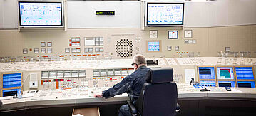 Ein Mitarbeiter sitzt an einem Kontroll- und Steuerungspult im Leitstand des Kernkraftwerk Brokdorf.