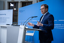 Carsten Schneider am Rednerpult bei der Pressekonferenz