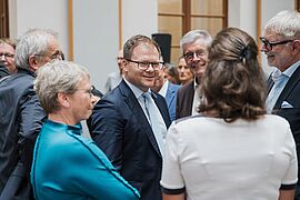 Carsten Schneider unterhält sich mit Teilnehmenden. 