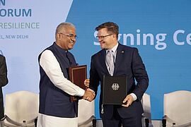 Der indische Umweltminister Bhupender Yadav und Bundesumweltminister Carsten Schneider geben sich die Hand.