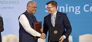 Der indische Umweltminister Bhupender Yadav und Bundesumweltminister Carsten Schneider geben sich die Hand.. Weitere Informationen siehe Bildunterschrift