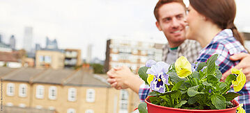 Ein Paar auf dem Balkon ihrer Wohnung.