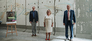 Dirk Messner, Svenja Schulze und Matthias Platzeck vor dem Mauerstück im BMU
