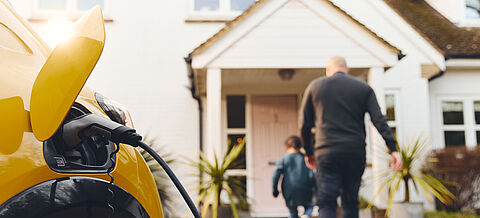Aufladen von Elektroauto in der Einfahrt vor dem Haus
